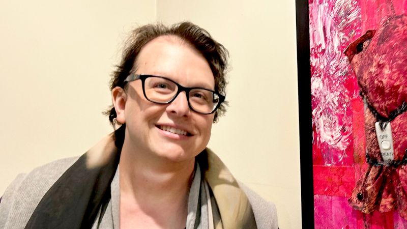 Photograph of Lisa G Hunter in front of a textile artwork she created.